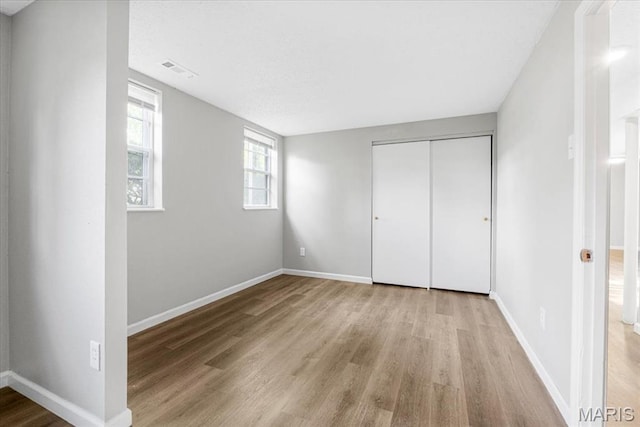 2145 Glenoro Dr, Florissant, MO 63033 - unfurnished bedroom featuring light wood-style floors, baseboards, and a closet