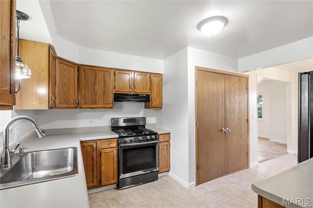 9506 B Rd, Valmeyer, IL 62295 - kitchen with stainless steel range with gas stovetop, a sink, exhaust hood, light countertops, and brown cabinetry