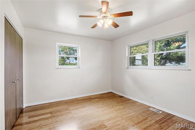 9506 B Rd, Valmeyer, IL 62295 - unfurnished bedroom featuring multiple windows, a closet, light wood-style floors, and baseboards