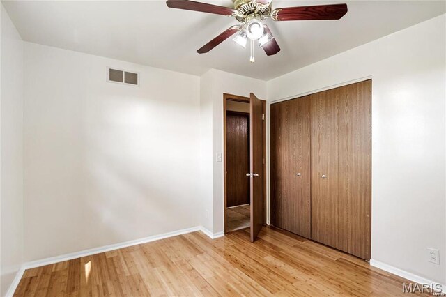 9506 B Rd, Valmeyer, IL 62295 - unfurnished bedroom with light wood-style flooring, a closet, baseboards, and a ceiling fan