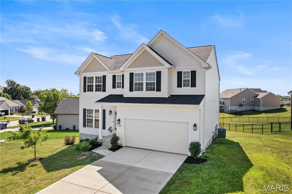 563 Crystal Stream Dr, Wentzville, MO 63385 - view of front facade featuring an attached garage, driveway, roof with shingles, board and batten siding, and a residential view