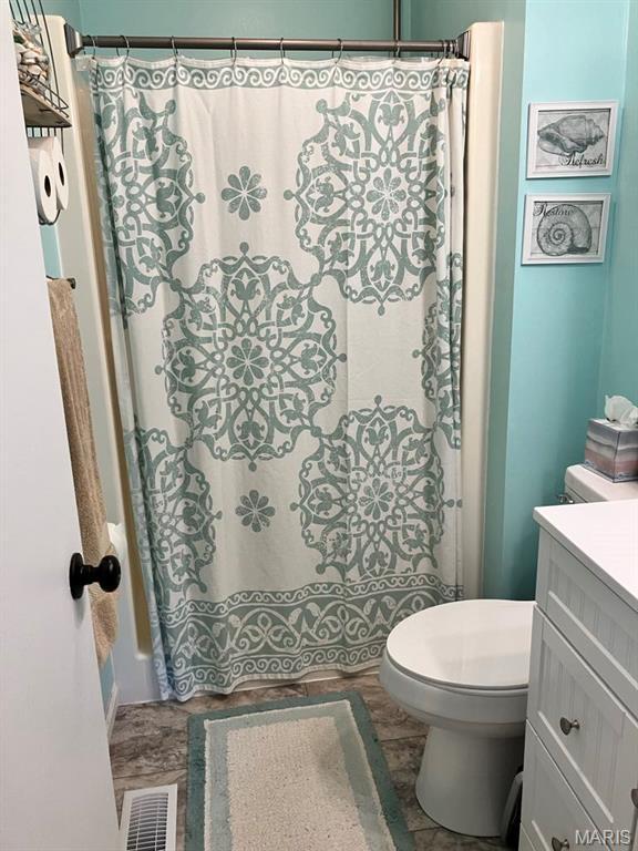 bathroom with vanity, toilet, and curtained shower