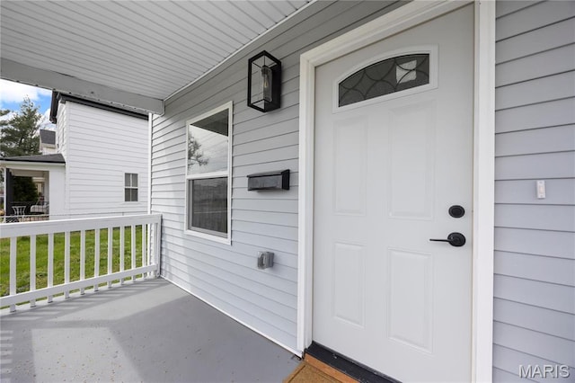 view of exterior entry featuring covered porch