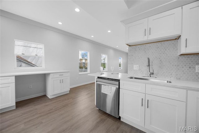 kitchen featuring stainless steel dishwasher, a sink, tasteful backsplash, crown molding, and recessed lighting