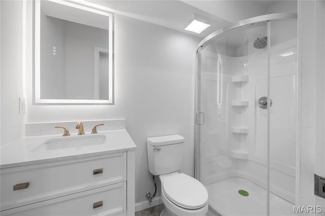 bathroom featuring a shower stall, toilet, and vanity