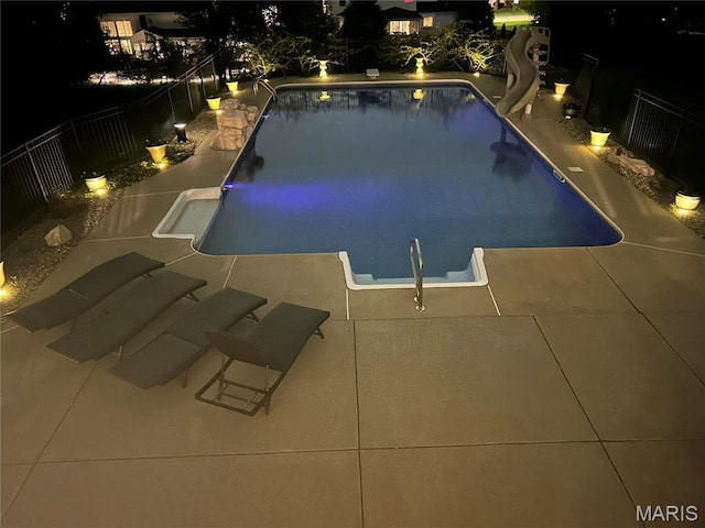 pool at twilight with a water slide, fence, and a patio area