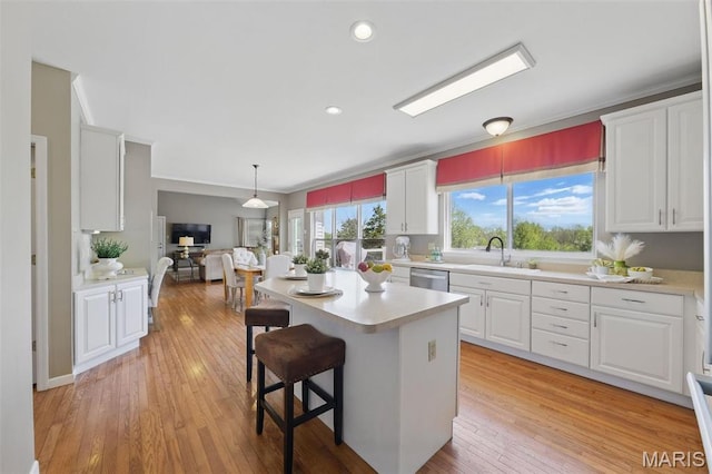 kitchen featuring a sink, light countertops, white cabinetry, dishwasher, and ornamental molding