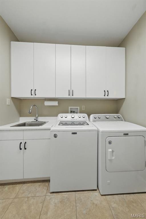 laundry room featuring independent washer and dryer, cabinet space, and light tile patterned floors