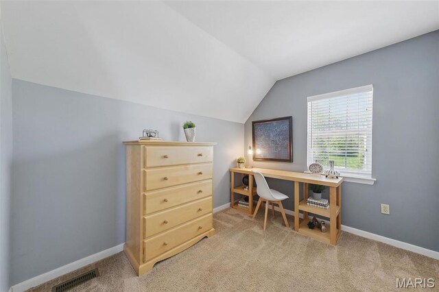 office area with vaulted ceiling, light colored carpet, and baseboards