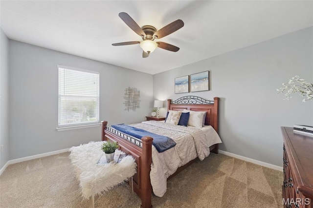 bedroom featuring light colored carpet, baseboards, and a ceiling fan