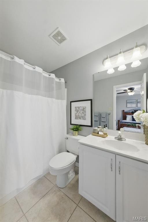 ensuite bathroom featuring tile patterned floors, vanity, ceiling fan, toilet, and a shower with curtain