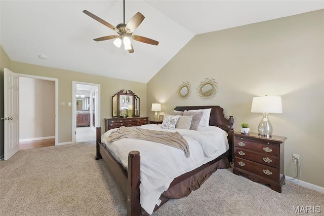 carpeted bedroom with lofted ceiling, baseboards, ceiling fan, and ensuite bath