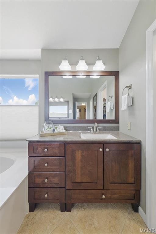 full bathroom with vanity, tile patterned floors, and a tub to relax in
