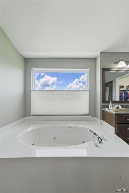 full bath featuring vanity and a jetted tub