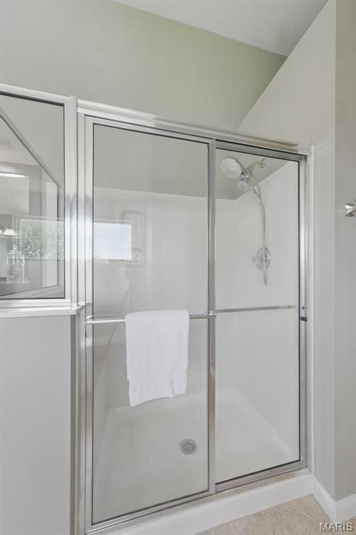 full bath with a stall shower, baseboards, and tile patterned flooring
