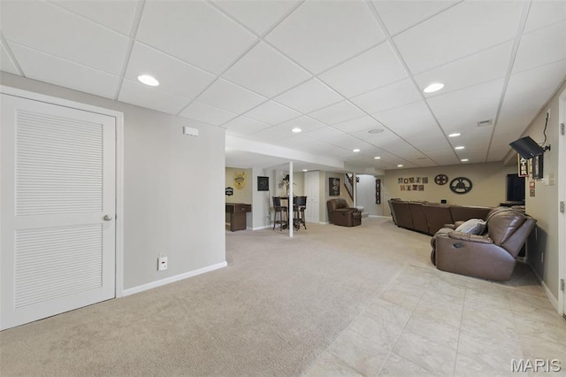 living room with carpet, baseboards, a drop ceiling, and recessed lighting