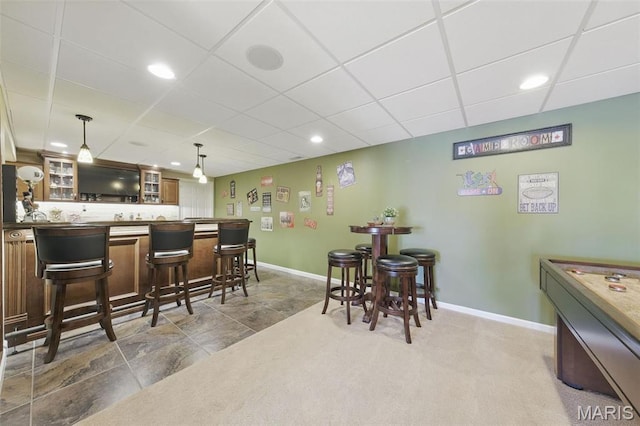 kitchen featuring a drop ceiling, baseboards, glass insert cabinets, decorative light fixtures, and recessed lighting