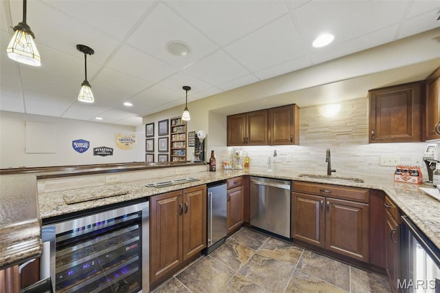 indoor bar with dishwasher, beverage cooler, decorative backsplash, hanging light fixtures, and dark stone finish flooring