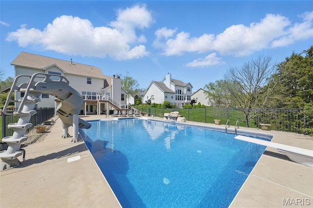 view of pool featuring fence, a diving board, stairway, a residential view, and a patio area