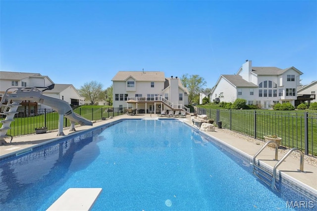 view of pool featuring a water slide, a diving board, and a residential view