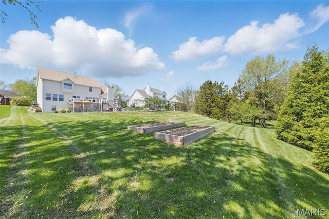 view of grassy yard featuring a vegetable garden