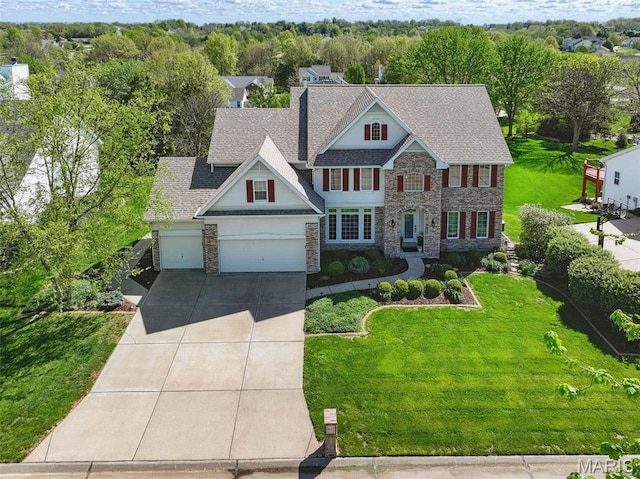 view of front of house featuring driveway, stone siding, an attached garage, and a front yard