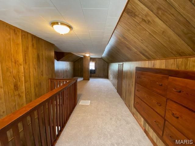 bonus room featuring wooden walls, lofted ceiling, and light carpet