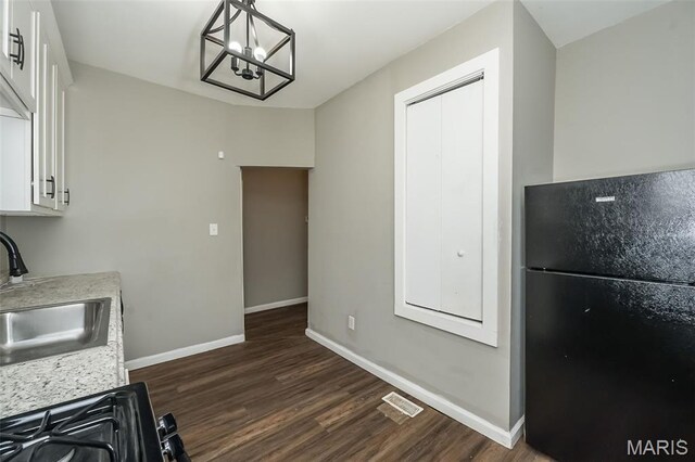 6211 Idaho Ave, Saint Louis, MO 63111 - kitchen with freestanding refrigerator, a sink, dark wood-type flooring, and a chandelier