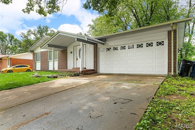 1455 Burnside Ct, Florissant, MO 63031 - view of front facade with brick siding, concrete driveway, a garage, and board and batten siding