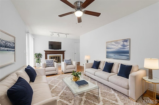 1455 Burnside Ct, Florissant, MO 63031 - living room featuring ceiling fan, rail lighting, a glass covered fireplace, and wood finished floors