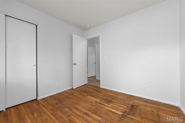 1455 Burnside Ct, Florissant, MO 63031 - unfurnished bedroom featuring wood finished floors, a closet, and baseboards