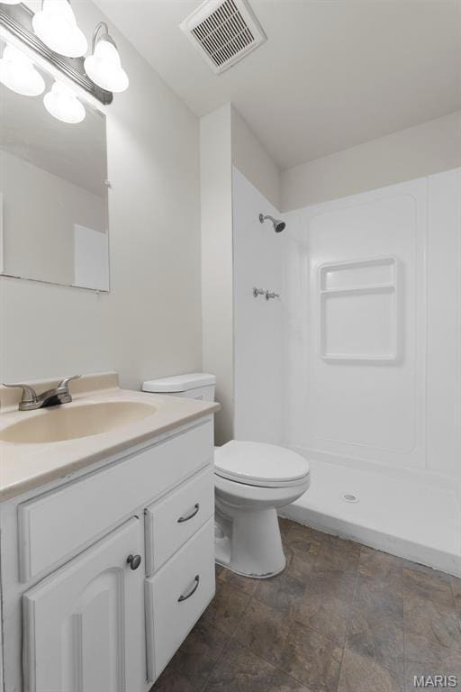 1455 Burnside Ct, Florissant, MO 63031 - bathroom with vanity, a shower, stone finish floors, and toilet