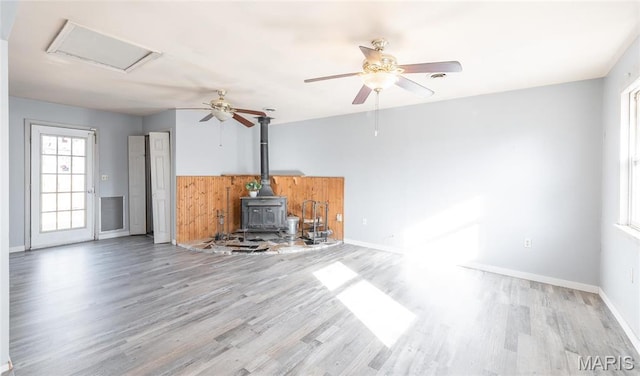 11 Saint Ann Ave, St James, MO 65559 - unfurnished living room with a wood stove, wood finished floors, ceiling fan, and baseboards