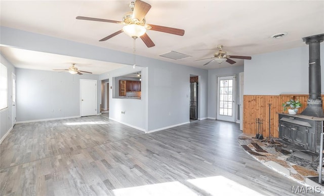 11 Saint Ann Ave, St James, MO 65559 - unfurnished living room with a wood stove, a ceiling fan, wood finished floors, and baseboards