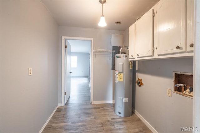 11 Saint Ann Ave, St James, MO 65559 - laundry room featuring electric water heater, light wood finished floors, cabinet space, and baseboards