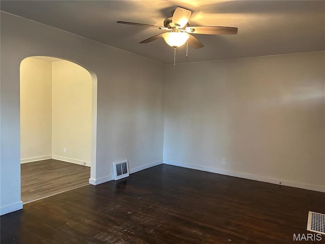 127 Whitelaw Ave, East Alton, IL 62024 - spare room featuring dark wood finished floors, ceiling fan, arched walkways, and baseboards