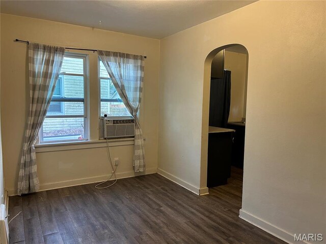 127 Whitelaw Ave, East Alton, IL 62024 - unfurnished room featuring dark wood finished floors, arched walkways, cooling unit, and baseboards