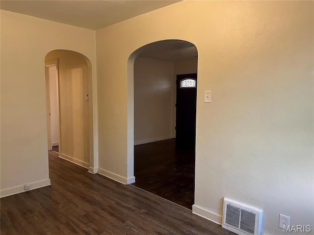 127 Whitelaw Ave, East Alton, IL 62024 - unfurnished room featuring dark wood-type flooring, baseboards, and arched walkways