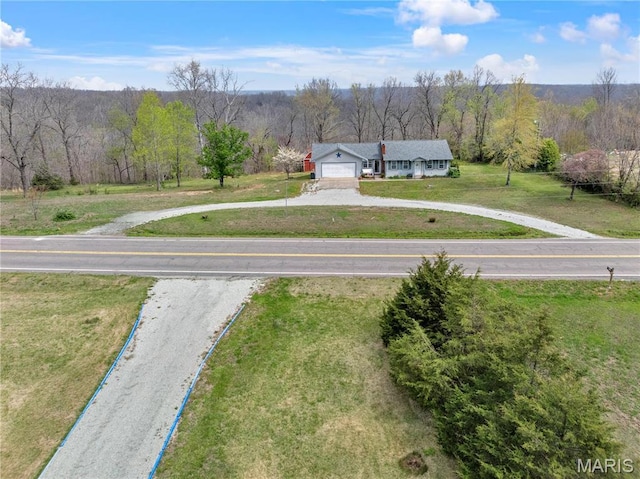 aerial view of property and surrounding area featuring a heavily wooded area