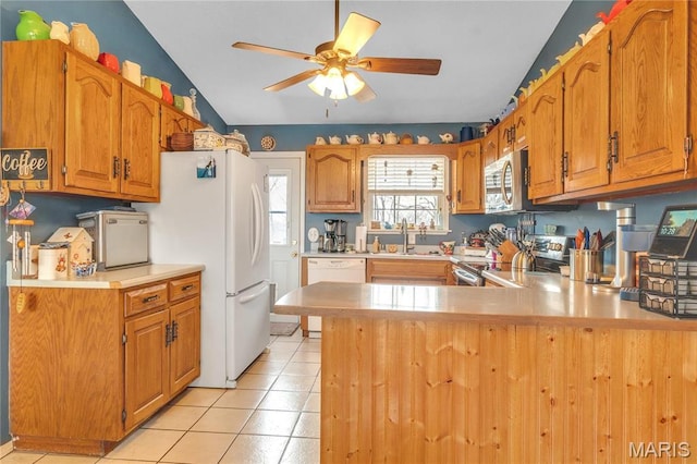 kitchen featuring a sink, ceiling fan, appliances with stainless steel finishes, light countertops, and a peninsula