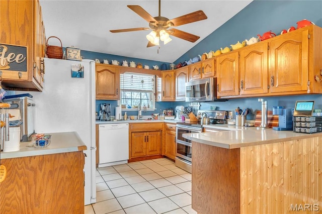 kitchen featuring stainless steel appliances, ceiling fan, lofted ceiling, a peninsula, and light tile patterned floors