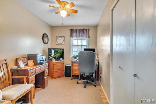 home office featuring a ceiling fan and light carpet