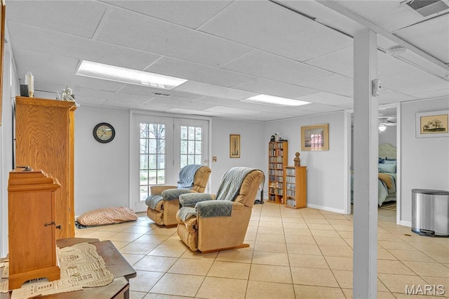 living room with light tile patterned floors and a paneled ceiling