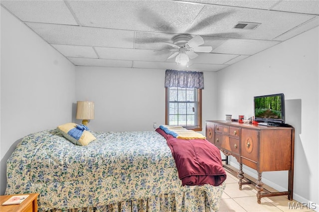 bedroom with light tile patterned floors, a drop ceiling, and ceiling fan