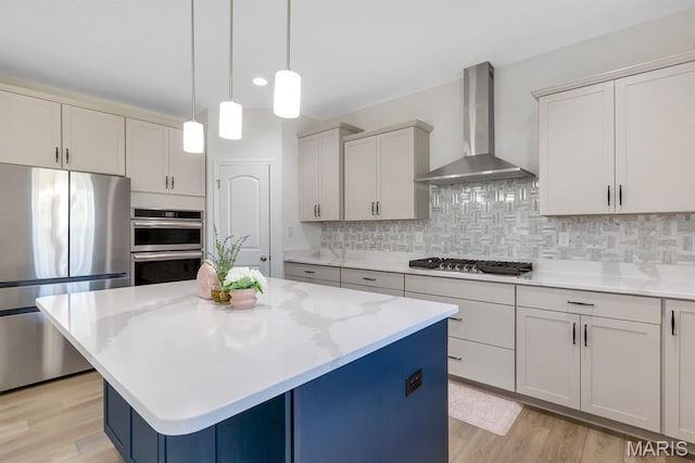 536 Edison Way, Wentzville, MO 63385 - kitchen featuring appliances with stainless steel finishes, wall chimney exhaust hood, decorative backsplash, light wood-style flooring, and recessed lighting