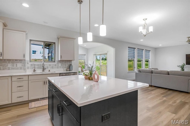 536 Edison Way, Wentzville, MO 63385 - kitchen with open floor plan, light countertops, light wood finished floors, decorative backsplash, and a sink