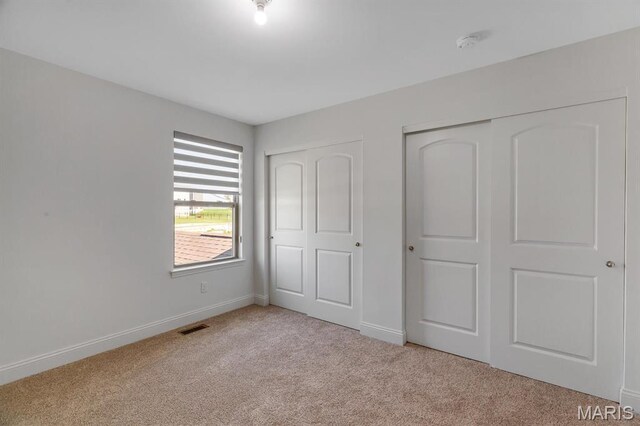 536 Edison Way, Wentzville, MO 63385 - unfurnished bedroom with multiple closets, carpet flooring, and baseboards