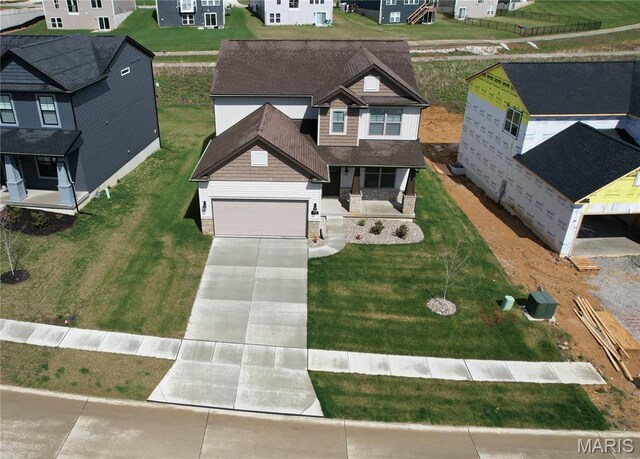 536 Edison Way, Wentzville, MO 63385 - view of front of property with a porch, concrete driveway, stone siding, a residential view, and a front yard