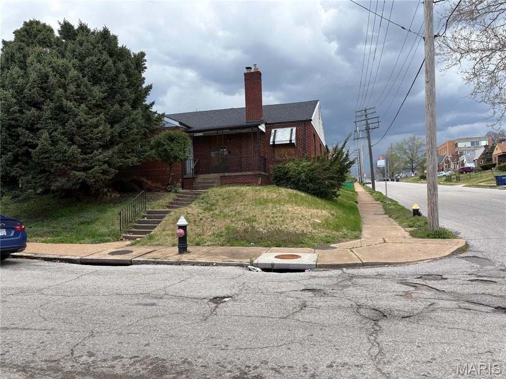8459 Newby St, Saint Louis, MO 63147 - view of front facade with brick siding and a chimney