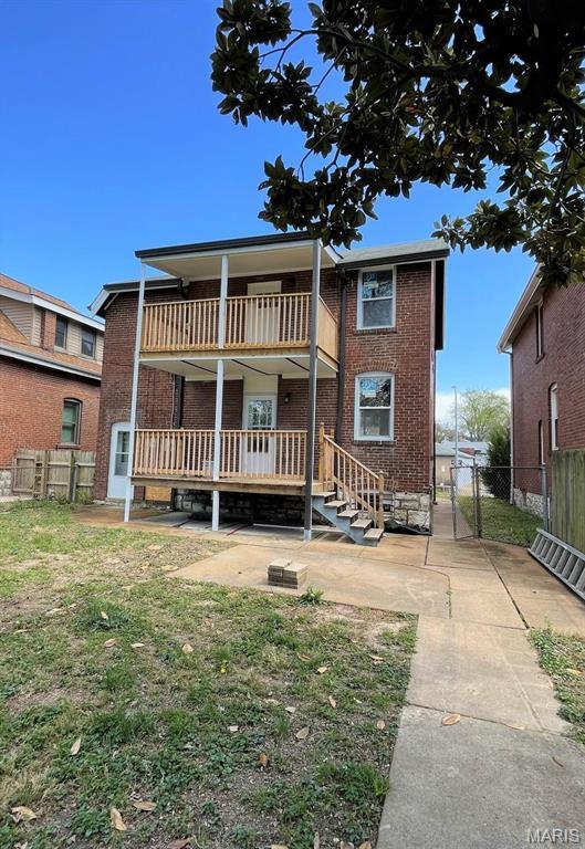 5811 Dewey Ave, Saint Louis, MO 63116 - back of house with brick siding, fence, a balcony, a wooden deck, and a gate